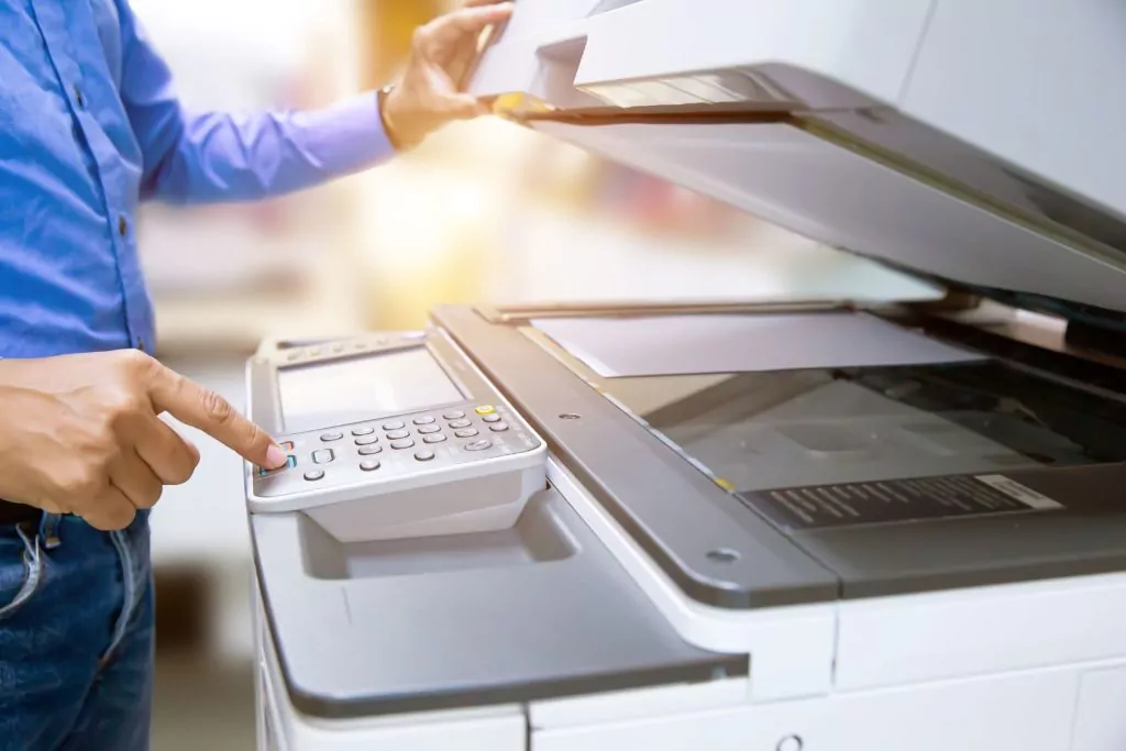 Close up of person's hand pressing copy button on panel of copier/scanner.